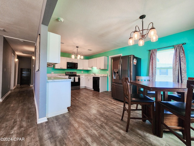 kitchen featuring black appliances, dark wood-type flooring, hanging light fixtures, and white cabinets