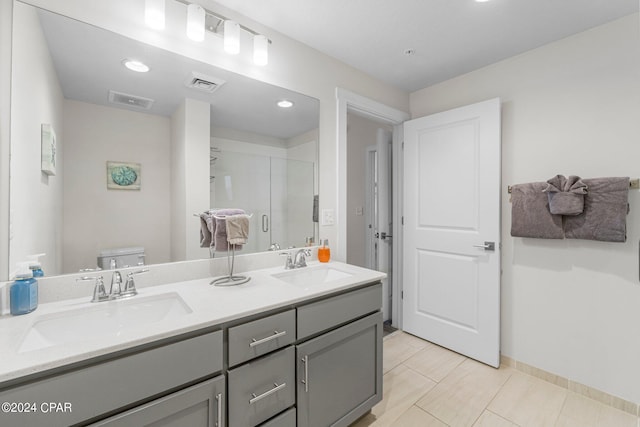 bathroom with dual vanity, toilet, a shower with door, and tile patterned flooring