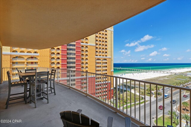 balcony featuring a water view and a beach view