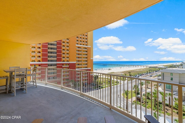 balcony featuring a water view and a beach view