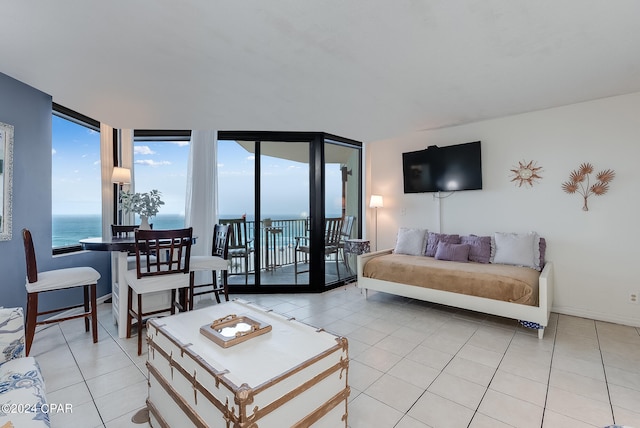 living room with a water view, floor to ceiling windows, and light tile patterned floors