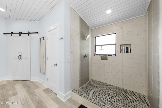 bathroom with hardwood / wood-style flooring, wood ceiling, and a tile shower