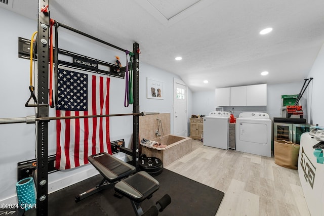 exercise area with independent washer and dryer, light hardwood / wood-style floors, and a textured ceiling