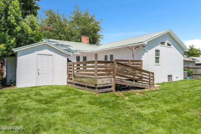 rear view of house with a deck and a lawn