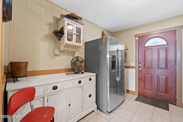 kitchen featuring white cabinetry, light tile patterned floors, and stainless steel fridge