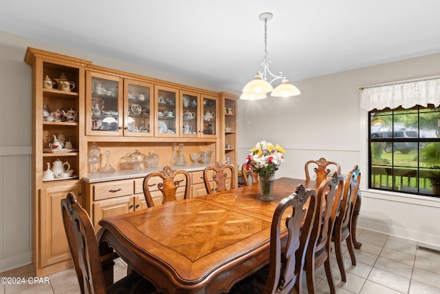 tiled dining space featuring an inviting chandelier