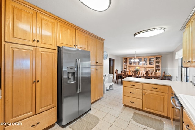 kitchen featuring stainless steel appliances, pendant lighting, a chandelier, and light tile patterned floors