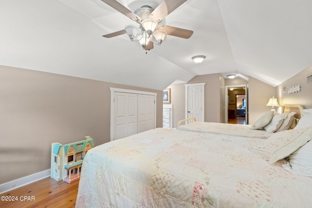 bedroom featuring ceiling fan, lofted ceiling, hardwood / wood-style floors, and a closet