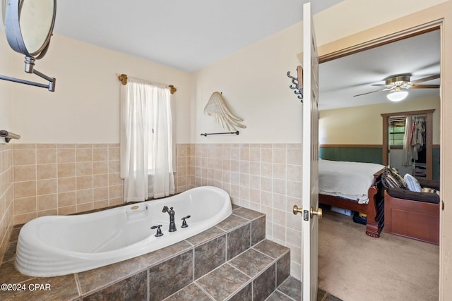 bathroom featuring ceiling fan and tiled bath