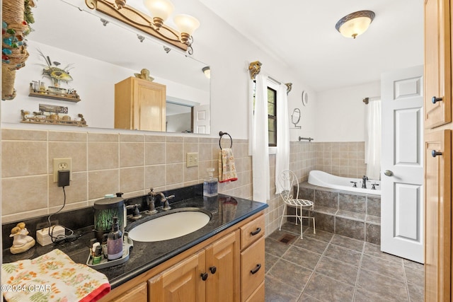 bathroom with tiled tub and vanity