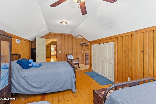 bedroom with ceiling fan, vaulted ceiling, and light hardwood / wood-style floors