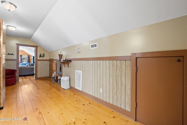 bonus room with wood-type flooring and vaulted ceiling