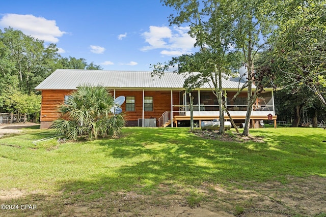 rear view of house with a yard and a sunroom