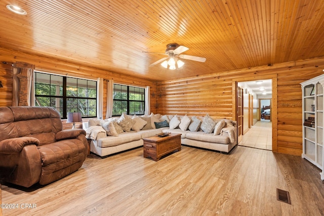 living room featuring ceiling fan, rustic walls, and light hardwood / wood-style floors