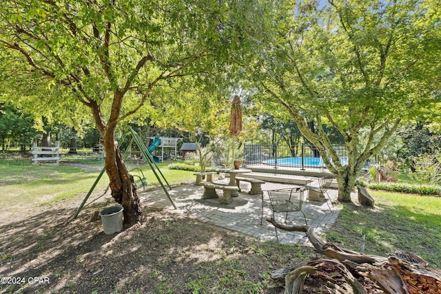 view of yard featuring a playground and a patio