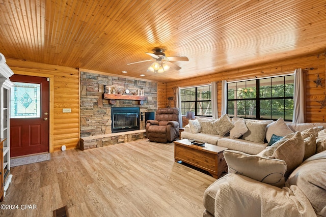 living room featuring a stone fireplace, plenty of natural light, log walls, and light wood-type flooring