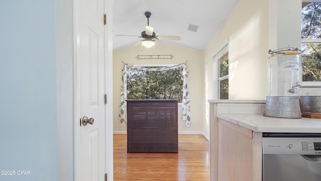 doorway with light wood-style floors, lofted ceiling, a wealth of natural light, and a ceiling fan