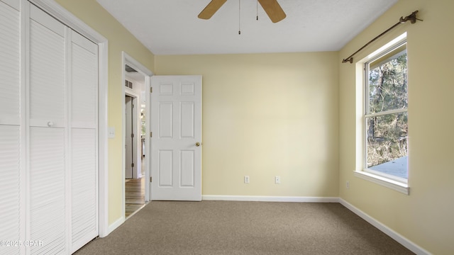 unfurnished bedroom with visible vents, a ceiling fan, baseboards, a closet, and carpet