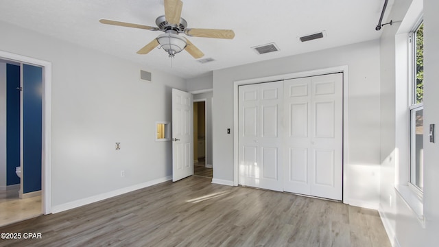 unfurnished bedroom with visible vents, baseboards, and wood finished floors