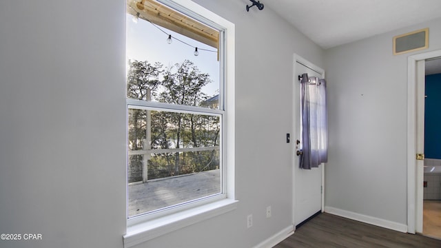 entryway with visible vents, baseboards, and dark wood-type flooring