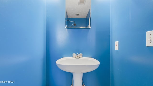 bathroom with visible vents and a textured ceiling