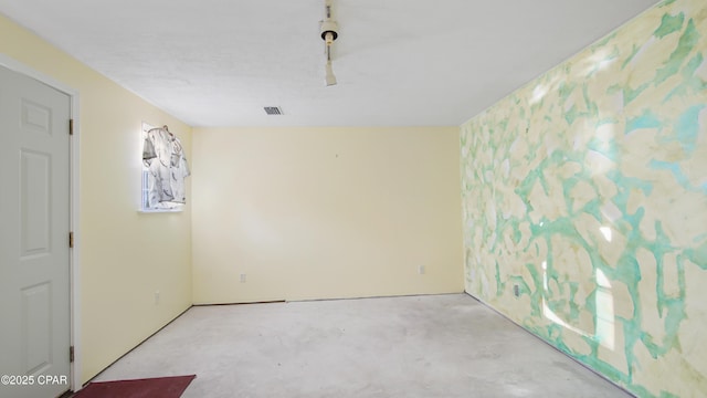 spare room featuring concrete floors and visible vents