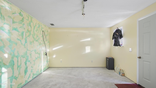 unfurnished room with concrete floors and visible vents