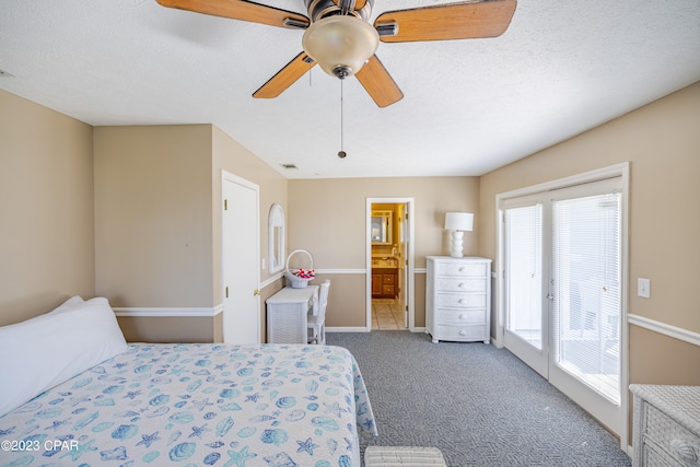 carpeted bedroom with ceiling fan, ensuite bathroom, access to exterior, and a textured ceiling