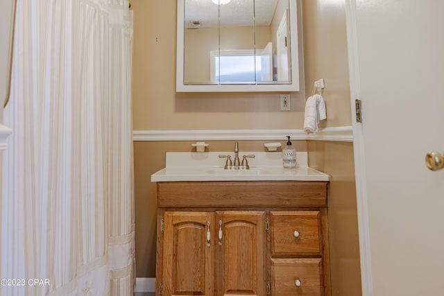 bathroom featuring a textured ceiling and vanity