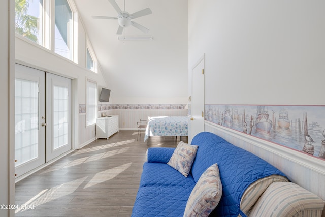 interior space featuring hardwood / wood-style flooring, access to exterior, high vaulted ceiling, ceiling fan, and french doors