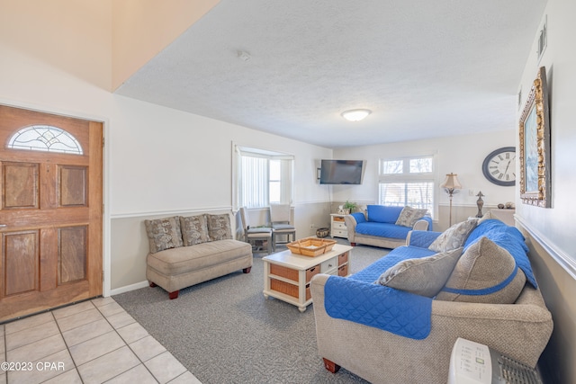 living room featuring a textured ceiling, plenty of natural light, and light tile patterned floors