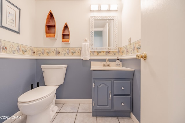 bathroom with tile patterned flooring, vanity, and toilet