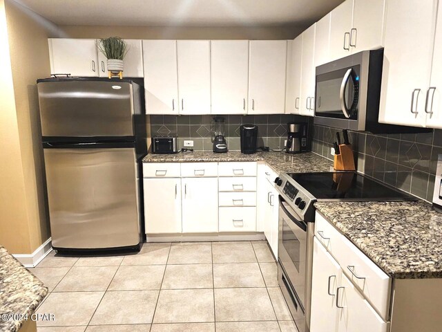 kitchen featuring backsplash, white cabinetry, light tile patterned floors, and appliances with stainless steel finishes