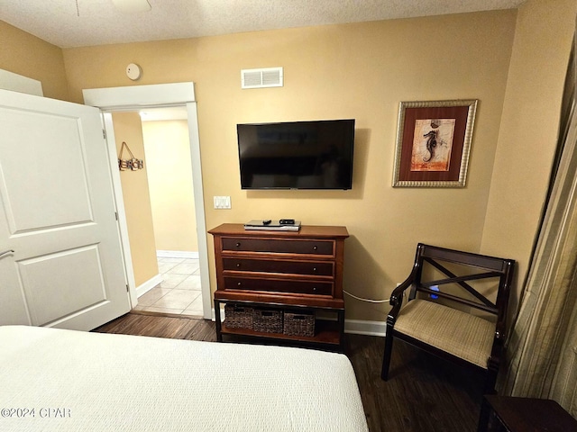 bedroom with wood-type flooring and a textured ceiling