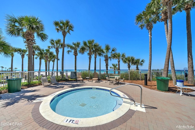 view of pool featuring a patio area and a water view