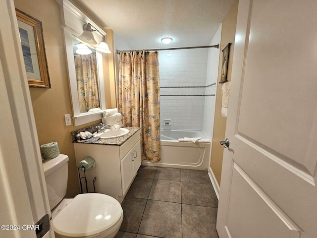 full bathroom featuring tile patterned flooring, a textured ceiling, toilet, shower / bath combo with shower curtain, and vanity