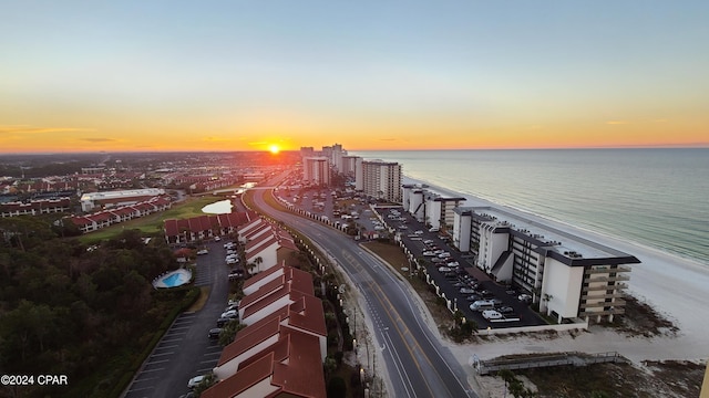 aerial view at dusk featuring a water view