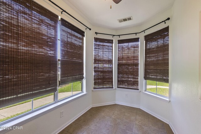 tiled empty room featuring ceiling fan