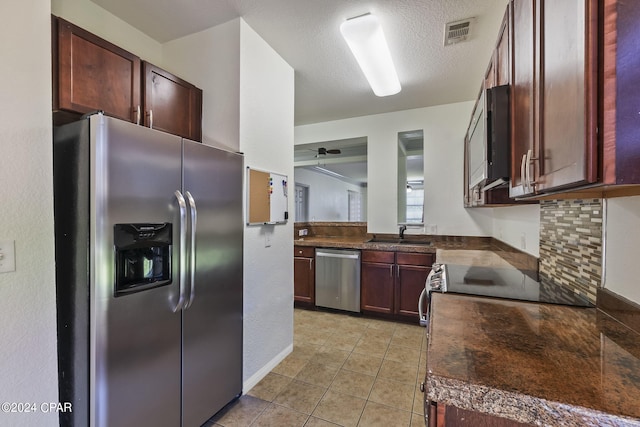 kitchen featuring light tile patterned floors, sink, ceiling fan, stainless steel appliances, and a textured ceiling