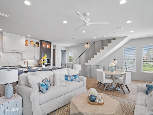 living room featuring light wood-type flooring and ceiling fan