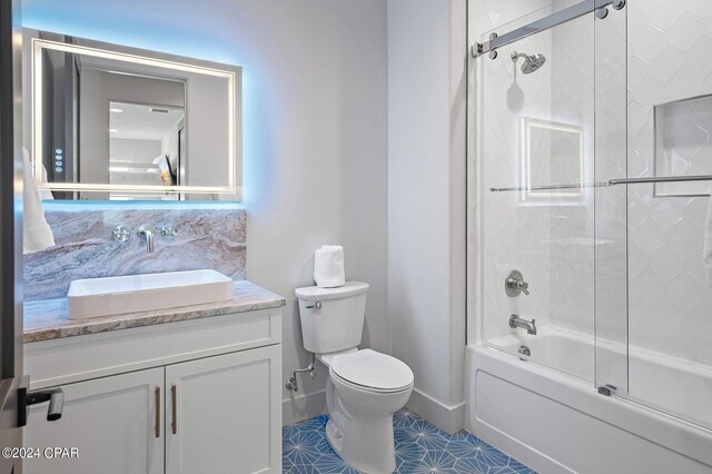 101 Deluna Pl Unit A, Panama City Beach, FL 32413 - bathroom with tile patterned flooring, bath / shower combo with glass door, toilet, and vanity
