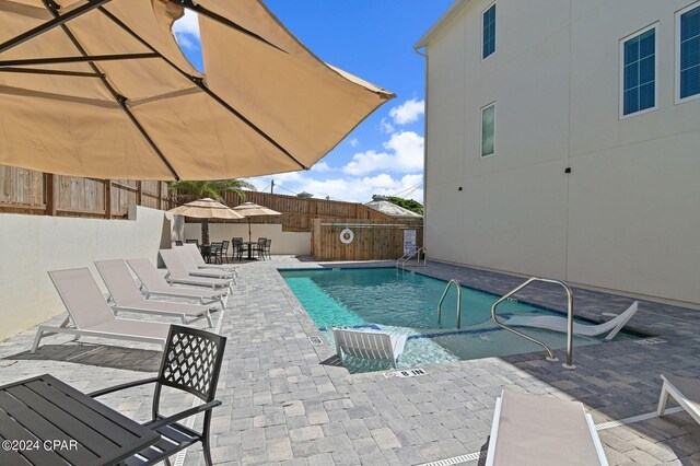 101 Deluna Pl Unit A, Panama City Beach, FL 32413 - community pool with a fenced backyard, a patio, and outdoor dining area