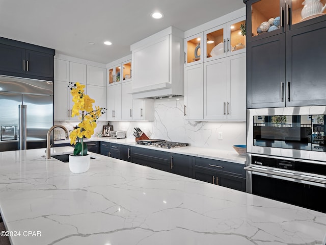 kitchen featuring white cabinets, light stone counters, and appliances with stainless steel finishes