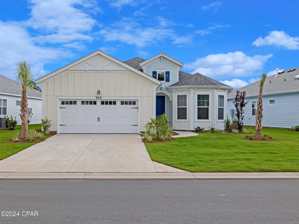 view of front of property with a garage, central AC unit, and a front yard