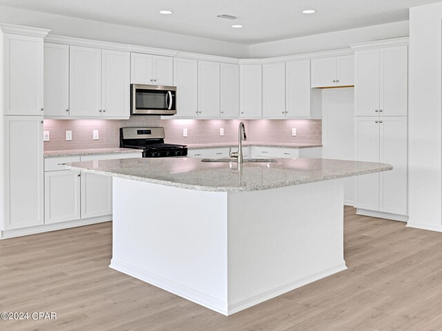 kitchen featuring sink, light hardwood / wood-style flooring, stainless steel appliances, and backsplash