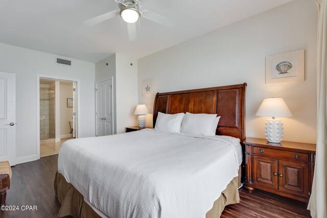 bedroom with ceiling fan, dark wood-type flooring, and ensuite bath