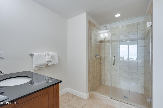 bathroom with tile patterned flooring, vanity, and a shower with door