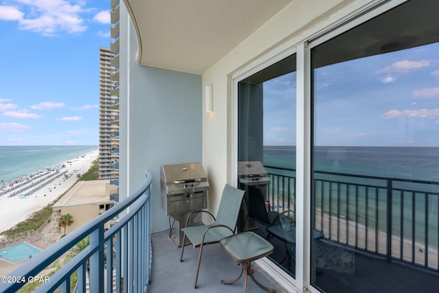 balcony with a beach view, a water view, and grilling area