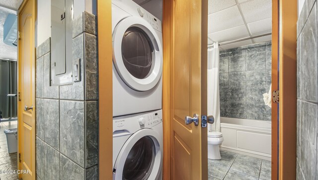 washroom featuring stacked washer / dryer and tile patterned flooring