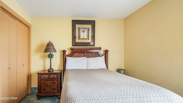 tiled bedroom with a closet and a textured ceiling